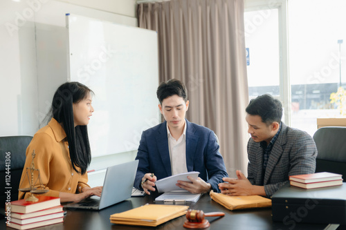 Asian lawyers in a modern office discussing contracts, law, and justice. Collaboration, documents, and determination showcased