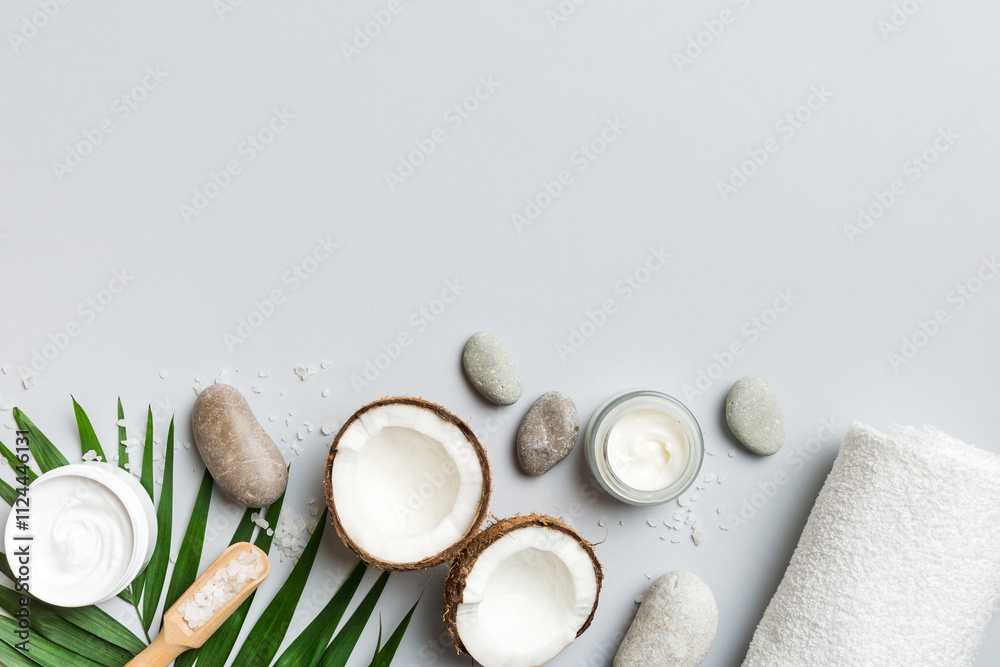 Fototapeta premium Coconut with jars of coconut oil and cosmetic cream on colored background. Top view. Free space for your text. Natural spa coconut cosmetics and organic treatment concept Coconut Spa composition