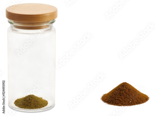 Cumin (Cuminum cyminum) The spice jar is a small, clear glass container with a sleek, cylindrical shape, standing upright photo