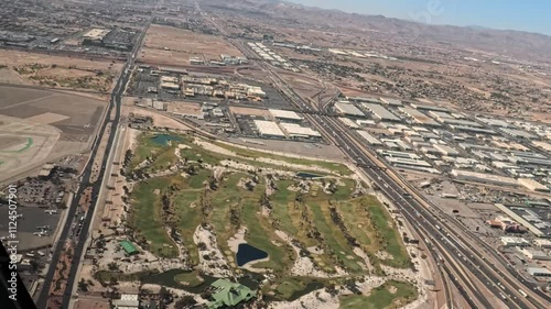 Footage through the front of a helicopter as it flies over the south end of the Las Vegas Strip then the golf course and over the airport