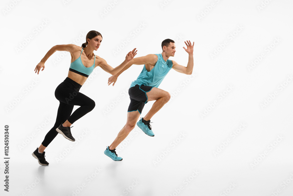 Full-length dynamic image of young athletic couple, man and woman in motion, running against white studio background. Endurance. Concept of sport, active and healthy lifestyle, workout, fitness Full-length dynamic image of young athletic couple, man and woman in motion, running against white studio background. Endurance. Concept of sport, active and healthy lifestyle, workout, fitness