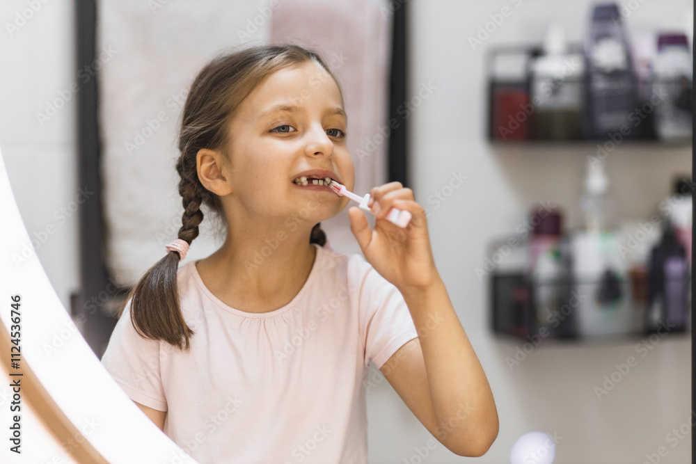 Young Caucasian girl brushing teeth in bathroom with focus on oral hygiene. Joyful expression and missing milk teeth add charm to daily routine. Young Caucasian girl brushing teeth in bathroom with focus on oral hygiene. Joyful expression and missing milk teeth add charm to daily routine.