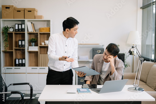 Furious two Asian businesspeople arguing strongly after making a mistake at work photo