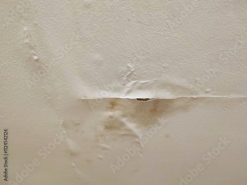 Damaged ceiling with peeling paint and water stains