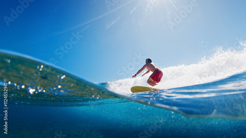 Surfer is riding a wave with the scene from above and below the surface. Maldives
