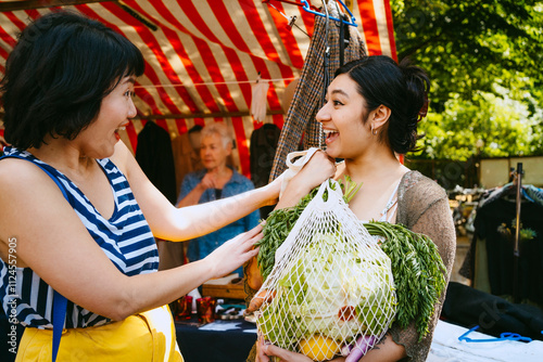 Women buying vegetables at a farmers market. photo