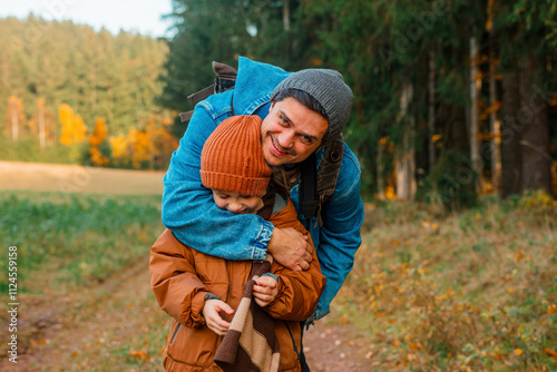 Smiling man hugging son in forest photo