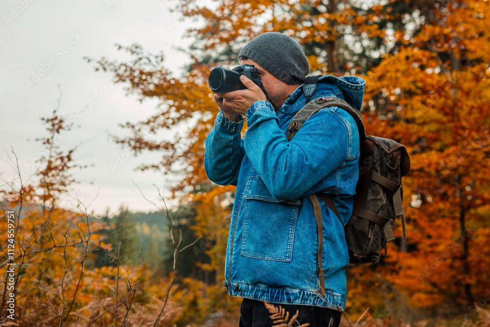 Man photographing through camera in autumn forest Man photographing through camera in autumn forest
