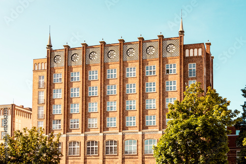 Neo-gothic red brick building in Hansa city, Rostock, Germany with clocks and symmetrical windows. photo