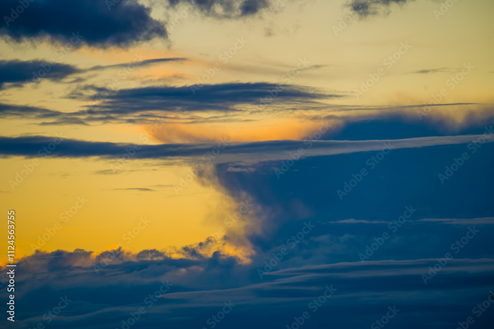 Naklejka premium Dark thunderclouds in yellow sky at sunset