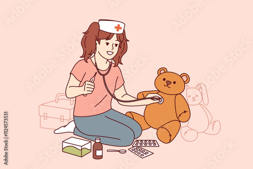 Little girl plays doctor, uses stethoscope and thermometer to treat teddy bear. Happy child plays doctor, dreams of becoming nurse or working in veterinary clinic and takes care of animals