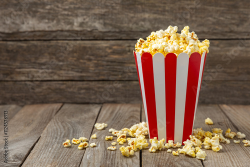 Popcorn box. Red and white striped buckets of salted popcorn on a colored background. Cinema and entertainment concept. Movie night with popcorn. Delicious appetizer, snack. Place for text.