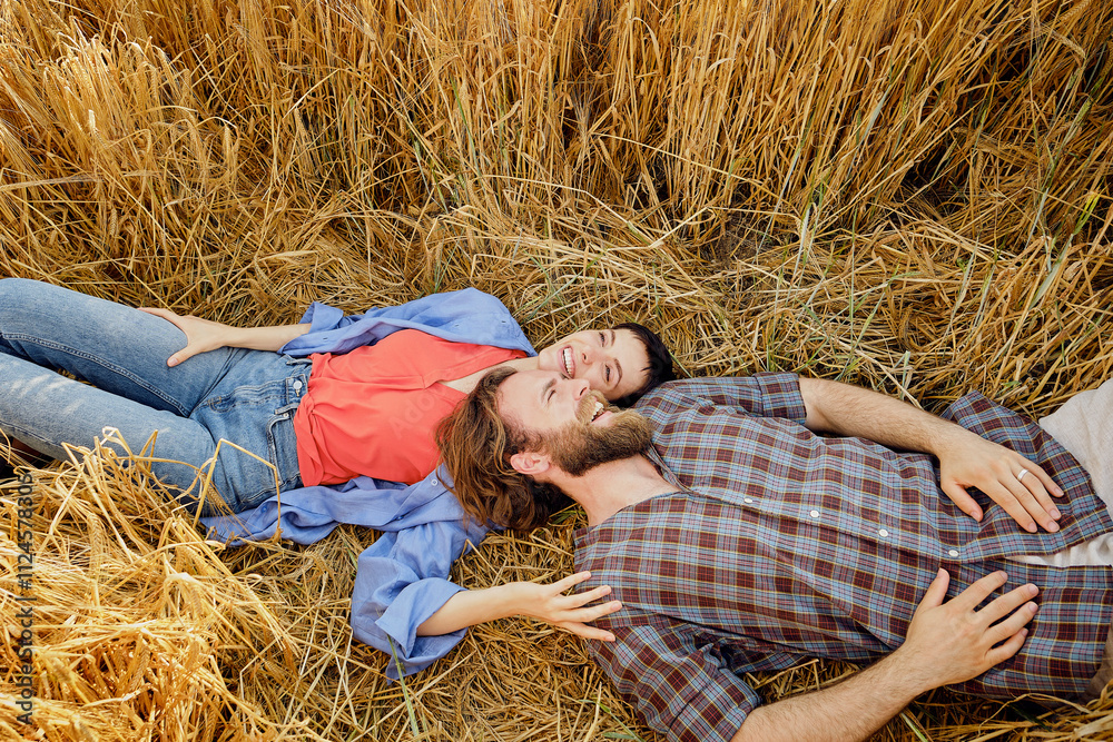 Happy couple lying down on dry hay Happy couple lying down on dry hay