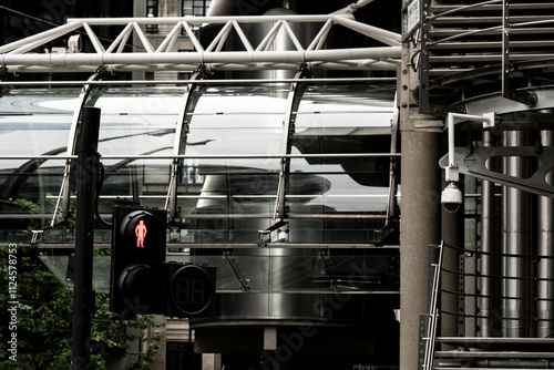 An urban scene featuring a crosswalk signal and glass structures, highlighting the intersection of pedestrian safety and modern architecture in a bustling city in London UK photo