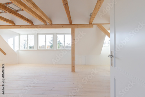 Bright attic space with wooden beams under construction photo