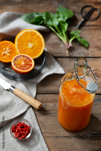 Orange and grapefruit juice in bottle on table photo