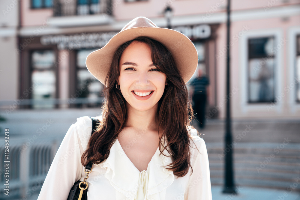 Portrait of young beautiful smiling hipster woman in trendy summer white blouse and jeans. Carefree woman posing in the street in sunny day. Positive model outdoors. Cheerful and happy Portrait of young beautiful smiling hipster woman in trendy summer white blouse and jeans. Carefree woman posing in the street in sunny day. Positive model outdoors. Cheerful and happy