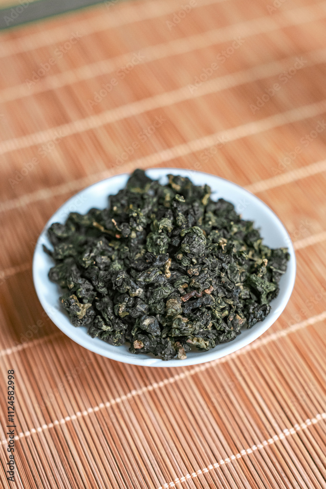 A beautiful bowl filled with Dried Green Tea Leaves showcasing their rich color and texture A beautiful bowl filled with Dried Green Tea Leaves showcasing their rich color and texture