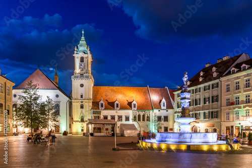 Illuminated view of Bratislava's Old Town square at night featuring the Old Town Hall and Maximilian Fountain photo