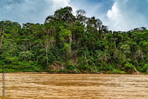 Heavy rain over the Amazon River and forest, with a small boat navigating the water amidst the storm photo