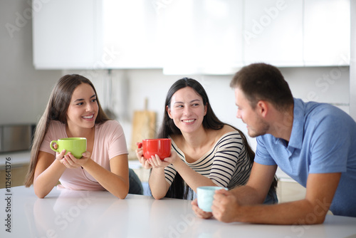 Three roommates talking at breakfast in the kitchen photo