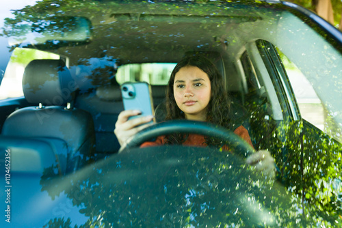 Distracted driving: teenager using phone behind the wheel, a risky and unlawful act
