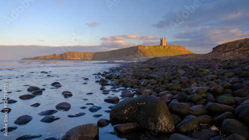 Sunset light on Dunstanburgh Castle, Northumberland photo