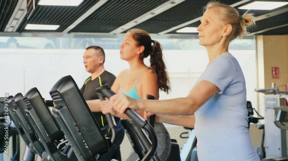 Mature female athlete working out at elliptical machine in gym Mature female athlete working out at elliptical machine in gym