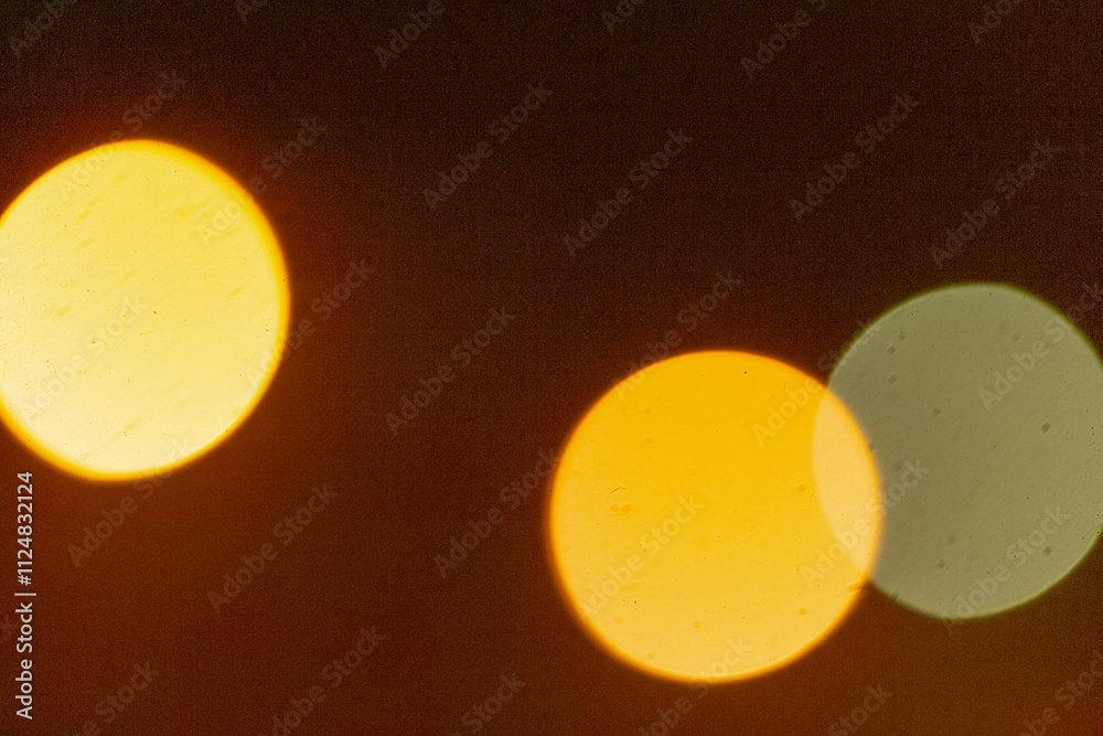 This image features a blurry depiction of two distinct yellow circles set against a contrasting dark background that enhances their presence This image features a blurry depiction of two distinct yellow circles set against a contrasting dark background that enhances their presence