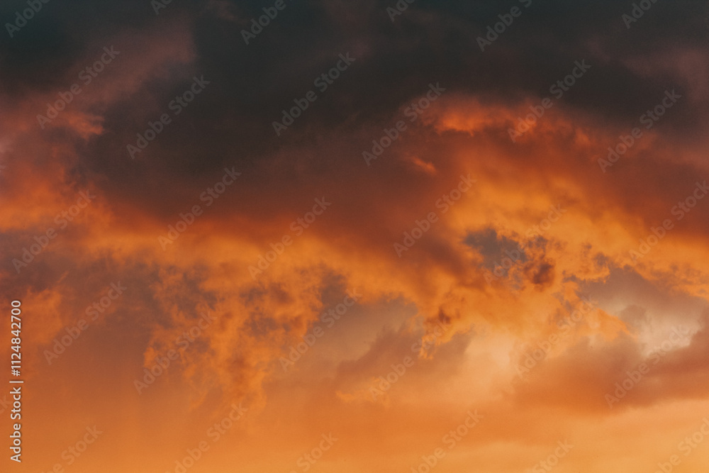 Moody storm clouds illuminated by vibrant sunset light—an inspiring backdrop for artistic or commercial use.