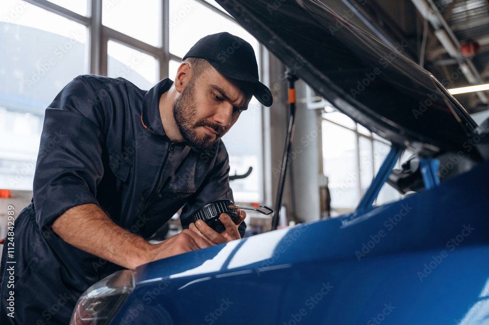 Focused at work. Mechanic is in a car service station Focused at work. Mechanic is in a car service station
