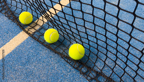 Foto Net of a blue paddle tennis court and balls