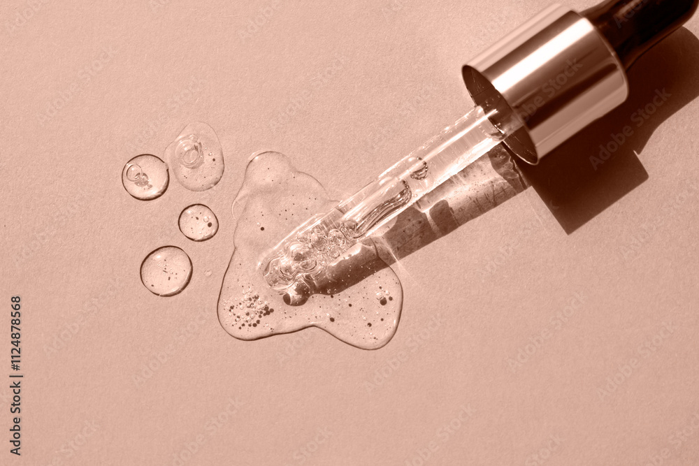 Serum drops and a pipette on a beige background. Top view. Color of the Year Mocha Mousse. Serum drops and a pipette on a beige background. Top view. Color of the Year Mocha Mousse.