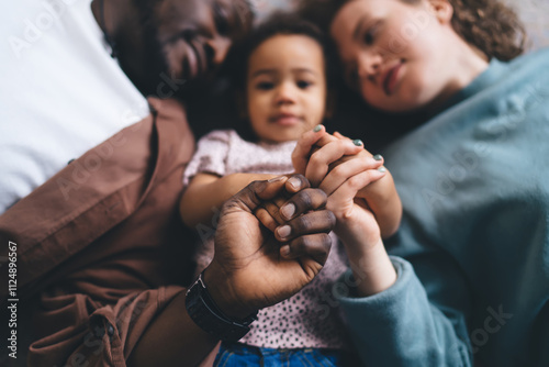 Photography Blurred photo of diverse family with selective focus on hands intertwined, child