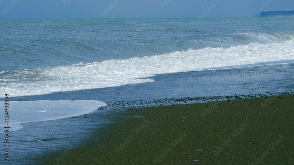 Stone Beach Of Small Pebbles Washed By Small Foamy Waves. Clear Water By The Sea. Still. Stone Beach Of Small Pebbles Washed By Small Foamy Waves. Clear Water By The Sea. Still.
