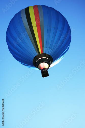 Vibrant blue hot air balloon floating against a clear sky, symbolizing sustainable, eco friendly transport, innovative green transportation and ecological tourism environmental awareness. Copy space
 photo