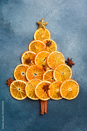 Christmas or New Year card. Christmas tree made of oranges. On a gray stone background. Top view.