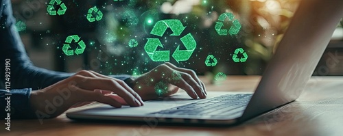 Hands typing on laptop with recycling symbols