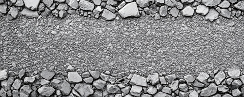 A textured surface featuring a mix of small and large stones, creating a natural border along a gravel path.