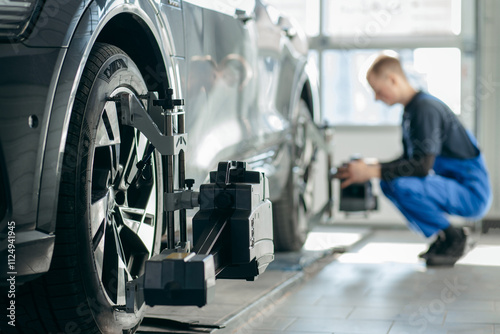 Wallpaper Mural Auto mechanic adjustment automobile wheel alignment work at repair service station Torontodigital.ca