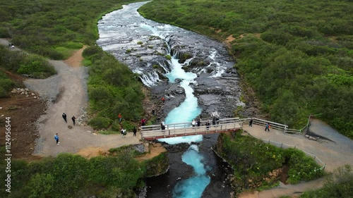 Approaching shot of Bruarfoss Waterfall and bridge in Iceland, aerial view