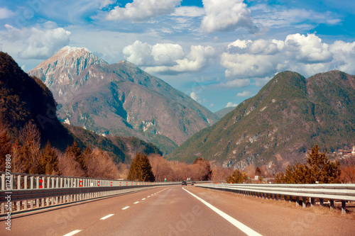 View of beautiful mountain landscape through the windscreen on a sunny day. Driving a car on mountain winding road in National park Picos de Europa. Cantabria, Spain, Europe photo