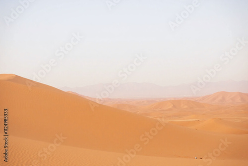 Serene desert landscape golden sand dunes mountains hazy mist sky gradient