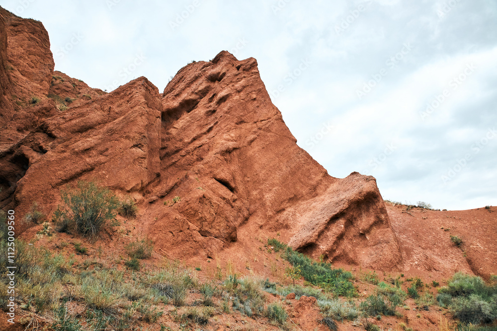 Travel destination Konorchek canyon, sheer cliffs subject to erosion, famous landmark Kyrgyzstan, Central Asia. Rock formation, natural landscape, hiking trekking area, sandstone red rocks Travel destination Konorchek canyon, sheer cliffs subject to erosion, famous landmark Kyrgyzstan, Central Asia. Rock formation, natural landscape, hiking trekking area, sandstone red rocks