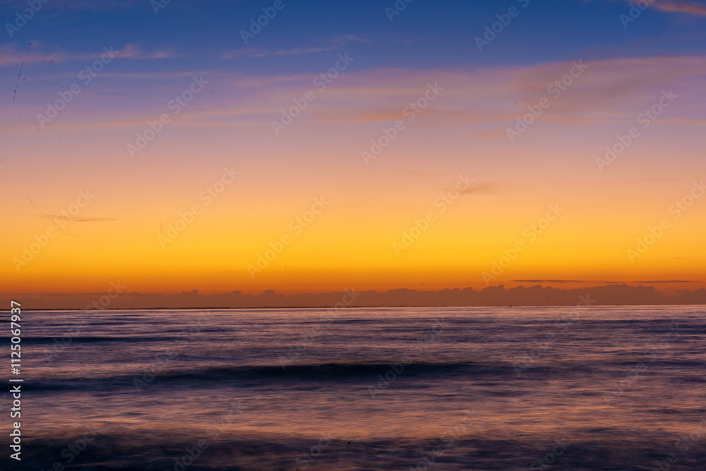 Naklejka premium Serene Ocean View With Vibrant Sunset And Gentle Waves