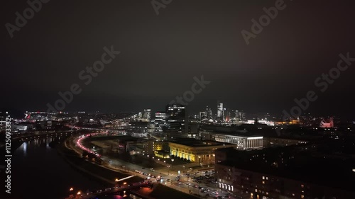 Wallpaper Mural Panoramic nighttime view of Vilnius city, showcasing illuminated buildings, landmarks, and a flowing river surrounded by urban lights. Torontodigital.ca