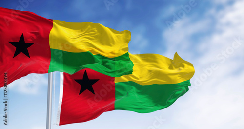 National flags of Guinea-Bissau waving in the wind on a clear day photo