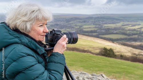 Elderly woman with gray hair using a professional camera on a tripod in golden-hour light, expressing passion for photography.