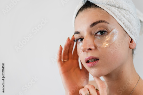 Caucasian woman in whie towel with collagen patch on face, skincare photo