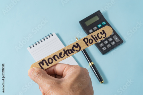 Financial concept with handwriting monetary policy on ice cream stick